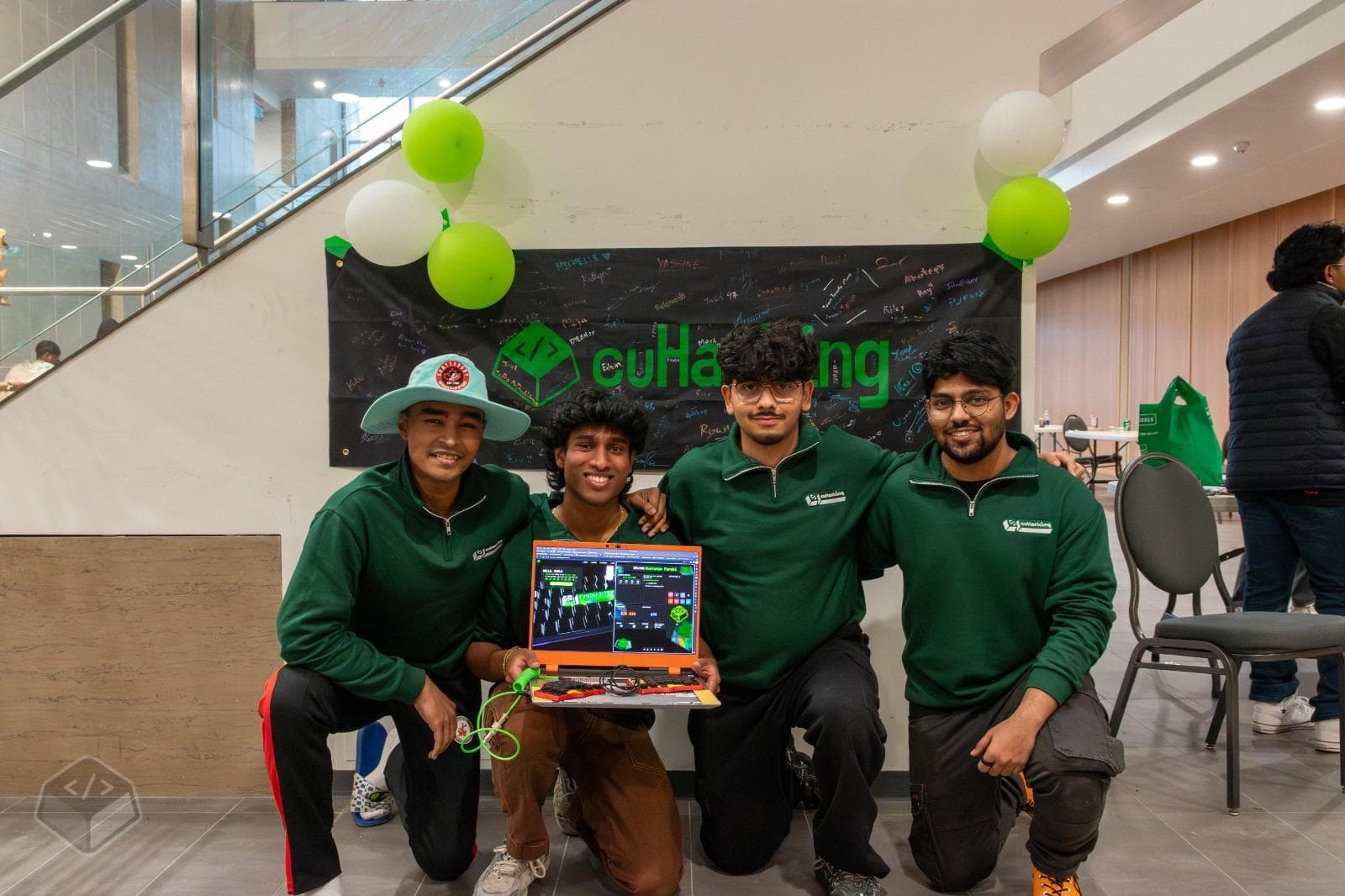 cuHacking organizers in green shirts under the cuHacking banner